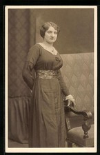 Foto-AK Frau im langen Kleid neben Sofa 