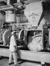 Bakery worker inspects dough