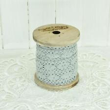 Spitze auf Holzspule in grau