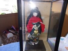 Japanische Geisha Puppe mit Kimono und Kugel am Band in der Hand, in Glaskasten