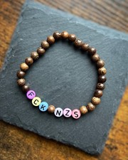 Perlenarmband „FCK NZS“ - Holz mit bunten Buchstaben - ca. 18cm