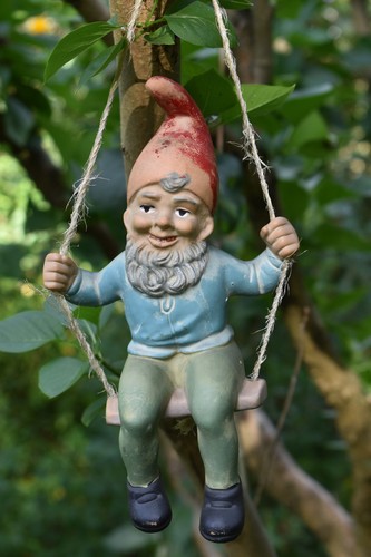 Alter gartenzwerg auf schaukel - auf,