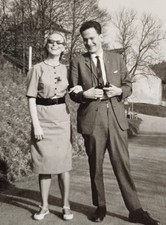 Paar steht Arm in Arm und lacht schöne Frau in 60er Jahre Mode Sonnenbrille Foto
