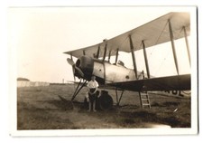 Fotografie Flugzeug Doppeldecker, Knabe neben Flugzeug stehend 