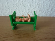 Baby in gelber Wiege in grün 80er Jahre D/EU