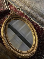 Prunkvoller  antike Spiegel–oval,mit vergoldetem Rahmen und floraler Verzierung