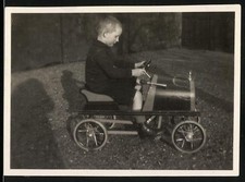 Fotografie Spielzeug Auto, Knabe fährt mit Tretauto / Draisine 