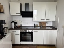 Küche mit E-Geräten (Backofen/Kühlschrank/Herd), Kommode, Tisch und Stühle