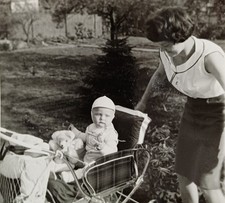 Frau Mutter blickt glücklich auf Baby mit Teddy im Kinderwagen 60er Jahre Foto