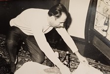 Mann kniet im Wohnzimmer vor