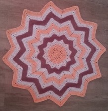 Kuscheldecke in Sternenform gehäkelt mit Rottönen Durchmesser ca. 85cm