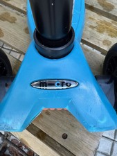 Maxi Micro Roller in hellblau mit schwarzen Rollen vorne, hintere Rolle leuchtet