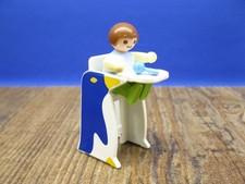 Baby im Hochstuhl mit Rassel