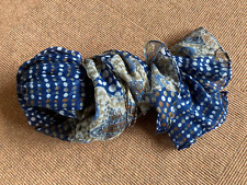 einfacher, dünner, blau-braun-weiß gepunkteter und gemusterter Schal, getragen