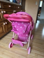 Puppenwagen mit Puppe und Rucksack.