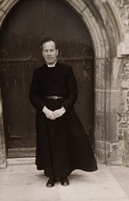 Pfarrer im Talar steht vor der