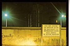Postkarte :  BERLIN  - Die  Berliner Mauer  mit Grenzschild  bei Nacht