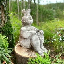 Sitzende Prinzessin mit großer Krone als robuste Steinfigur.