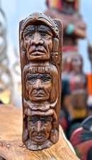 Totempfahl mit drei geschnitzten Gesichtern, indigene Völker, Indianer, Winnetou