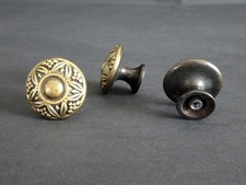 Drei runde Schrank- bzw. Schubladengriffe messingfarben mit sternförmigem Dekor.