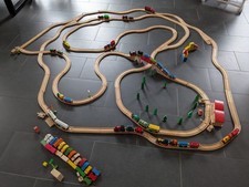 Holzeisenbahn mit Schienen, Zügen, Häusern, Autos, Bäumen, Schildern