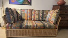 Hochwertiges Rattan-Schlafsofa mit farbenfrohem Polsterbezug