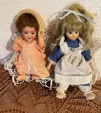 Zwei alte Porzellanpuppen auf einer Bank