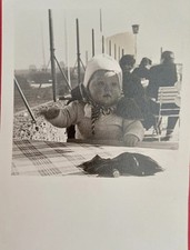 Sehr süßes Baby Kleinkind sitzt am Tisch im Cafe Mütze Cape Altes Foto