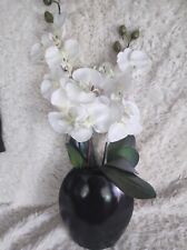 Weiße Orchidee im schwarzen Topf 
