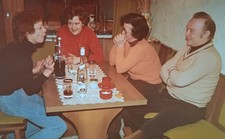 Drei Frauen sitzen mit Mann