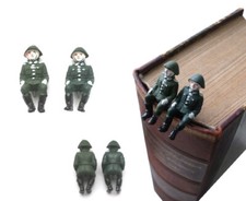 2x DDR NVA Soldat sitzend (in