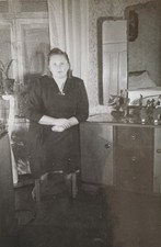 Schüchterne Frau sitzt 1955 an einer Frisierkommode im Schlafzimmer Foto