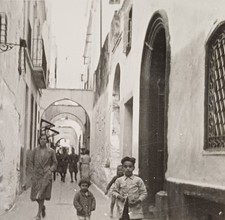 Frau geht mit drei Kindern in einer Straße in Marokko Soldaten in Uniform Foto