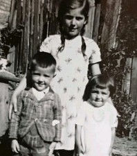 Mädchen mit Zöpfen steht mit kleinem Jungen Bruder & Schwester Geschwister Foto