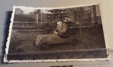 Altes Foto kleiner Junge mit Mütze in Tretauto
