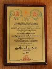 Urkunde(?) Arabische Schrift auf einer Metallplatte, auf einem Holzsockel ruhend