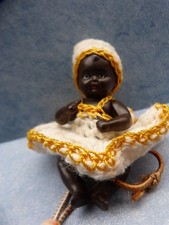 Kleine farbige Puppe als Tropfenfänger für Kaffeekanne