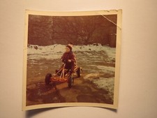 kleiner Junge mit Mütze fahrt im Winter mit Spielzeug Kettcar ? Tretauto / Foto