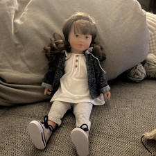 Käthe Kruse Puppe Glückskind mit brauen Haaren und zwei gelockten Zöpfen 