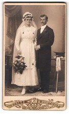 Fotografie Brautpaar im Hochzeitskleid mit Schleier und im Anzug, Zylinder auf  