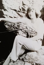 Frau sitzt auf einem Felsen