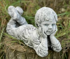 Steinfigur liegender Junge