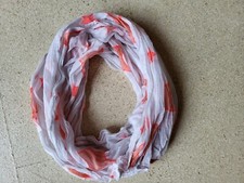 Loop- Schal, Grundfarbe weiß, mit neon-orangen Sternen. 