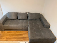 gebrauchte L-Couch / Sofa in grauem Velours (elektr. ausfahrbar)