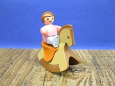 Baby mit Schaukelpferd Figur