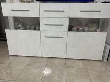 Weißes Sideboard, Glastüren und silberfarbenen Griffen.