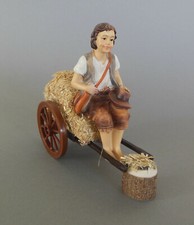 Hirte auf Strohwagen sitzend