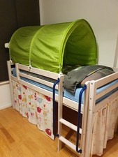 ein Hochbett mit Rutsche, Tunnel, Vorhängen, Lattenrosten und einer Matratze