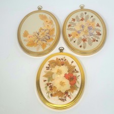 Drei Vintage ovale getrocknete gepresste Blumen/Gräser in Goldton auf Seide/Rahmen